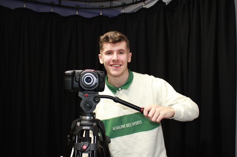 A young male student with a camera on a tripod